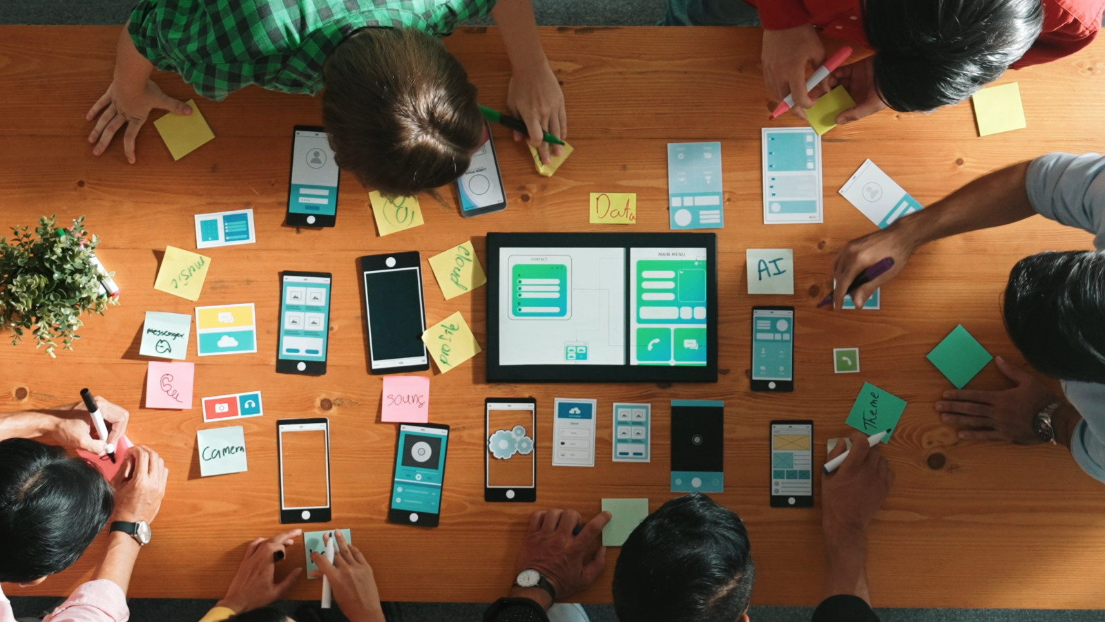 Team an einem Schfreibtisch mit Arbeitsmaterialien