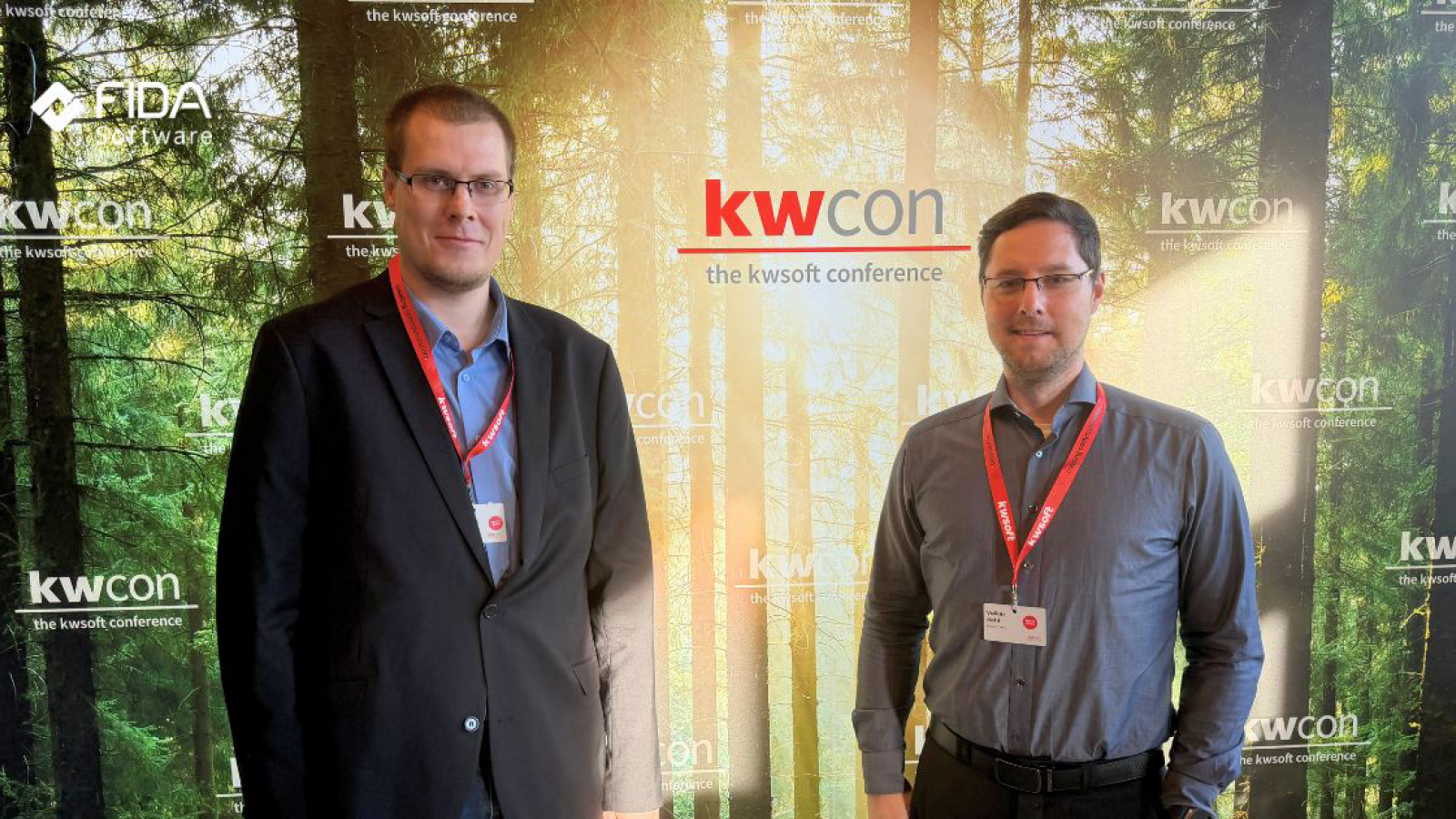 Zwei Personen vor einer Werbewand